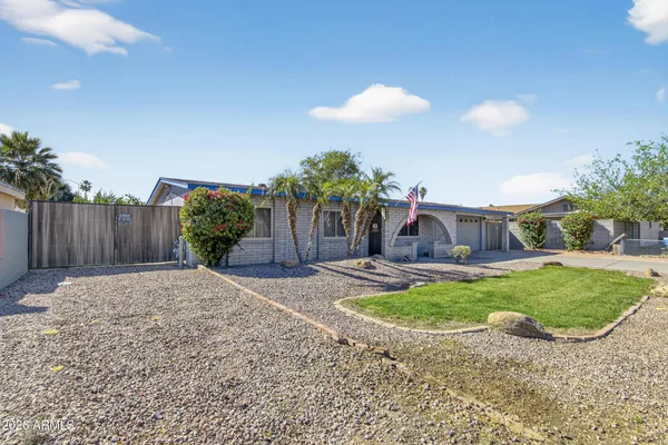 a backyard of a house with table and chairs plants and wooden fence
