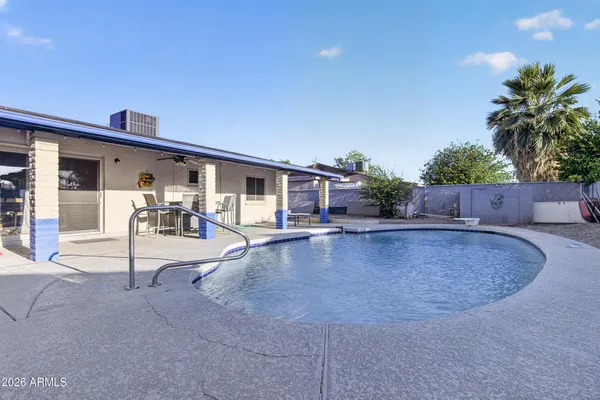 a view of a patio with table and chairs with plants and wooden fence
