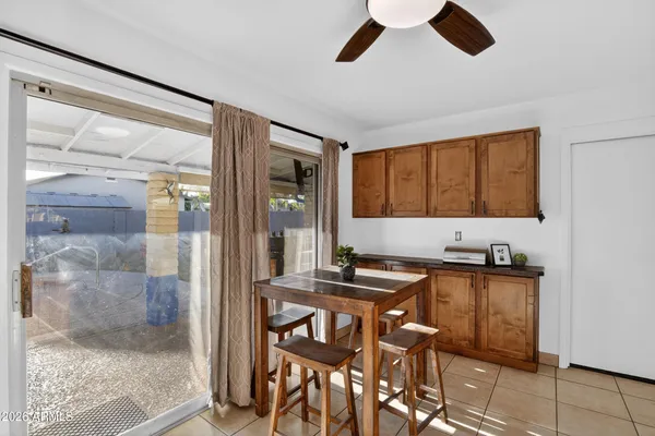 a kitchen with stainless steel appliances granite countertop a stove a refrigerator a sink a dining table and chairs with wooden floor