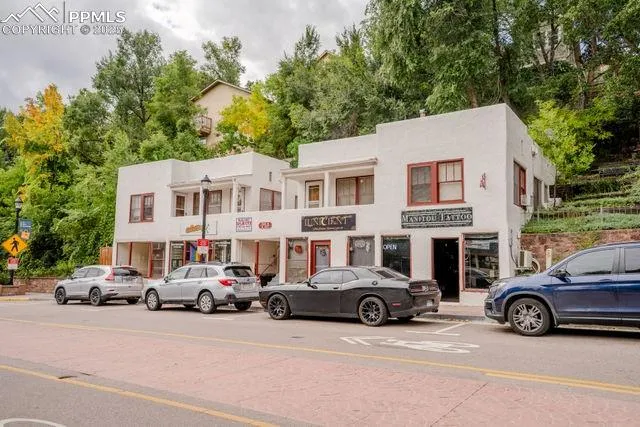 a front view of a house with a yard and potted plants