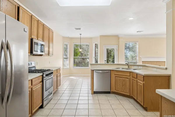 a kitchen with stainless steel appliances granite countertop a stove a sink and a refrigerator