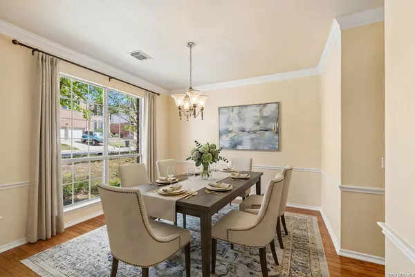a dining room with furniture a chandelier and wooden floor