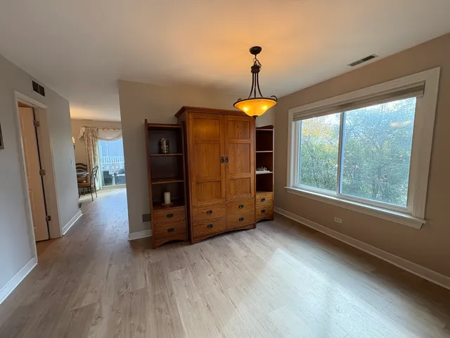 a view of an empty room with window and wooden floor