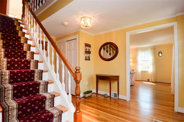 107 Viscount Road Longmeadow, MA 01106 - Photo 3 of 30 a view of a hallway with wooden floor and a clock on a wall