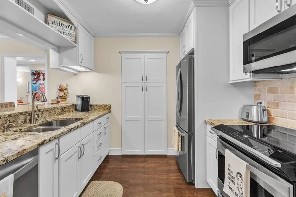 a kitchen with stainless steel appliances granite countertop a sink stove and refrigerator