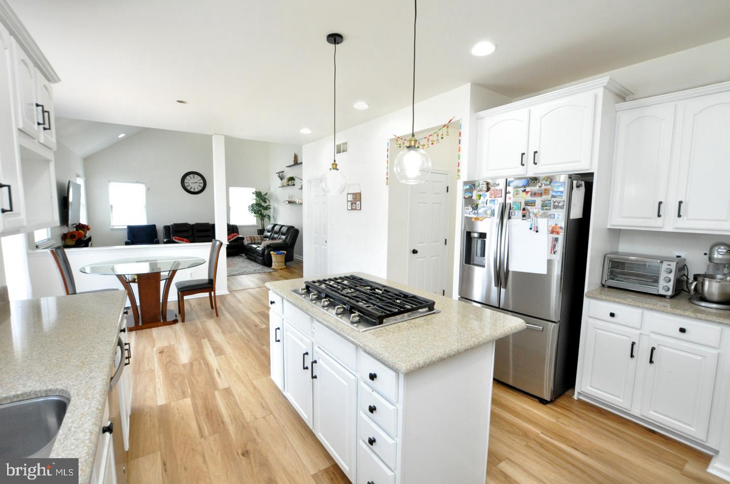 8 Jasmine Way Sewell, NJ 08080 - Photo 14 of 38 a kitchen with stainless steel appliances granite countertop a refrigerator a stove and white cabinets with wooden floor
