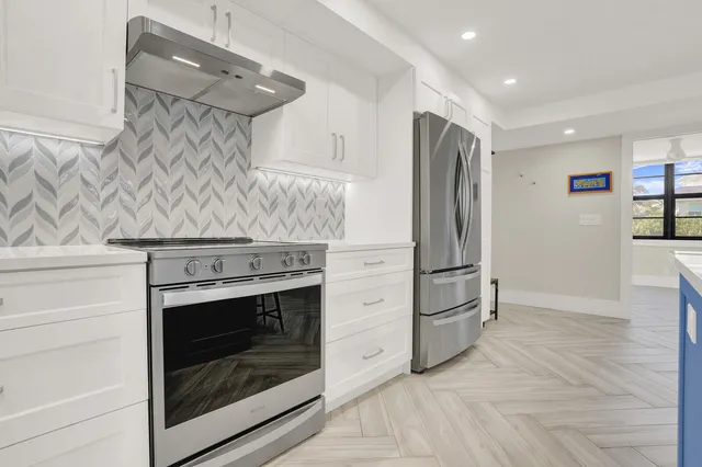 a kitchen with stainless steel appliances granite countertop a stove and a refrigerator