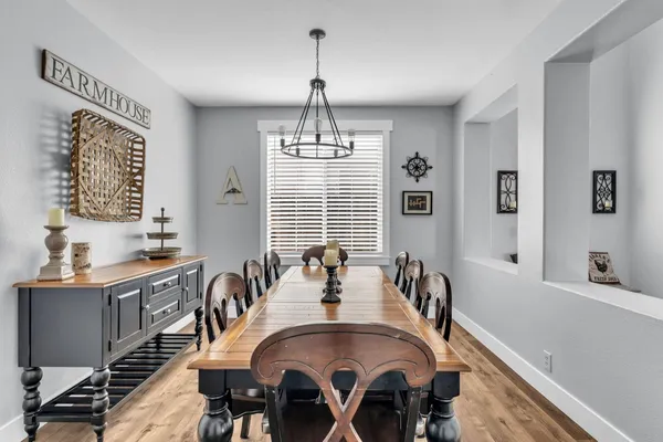 a dining room with furniture a chandelier and wooden floor