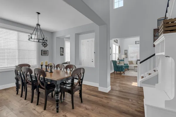 a kitchen with stainless steel appliances granite countertop a dining table chairs refrigerator and cabinets