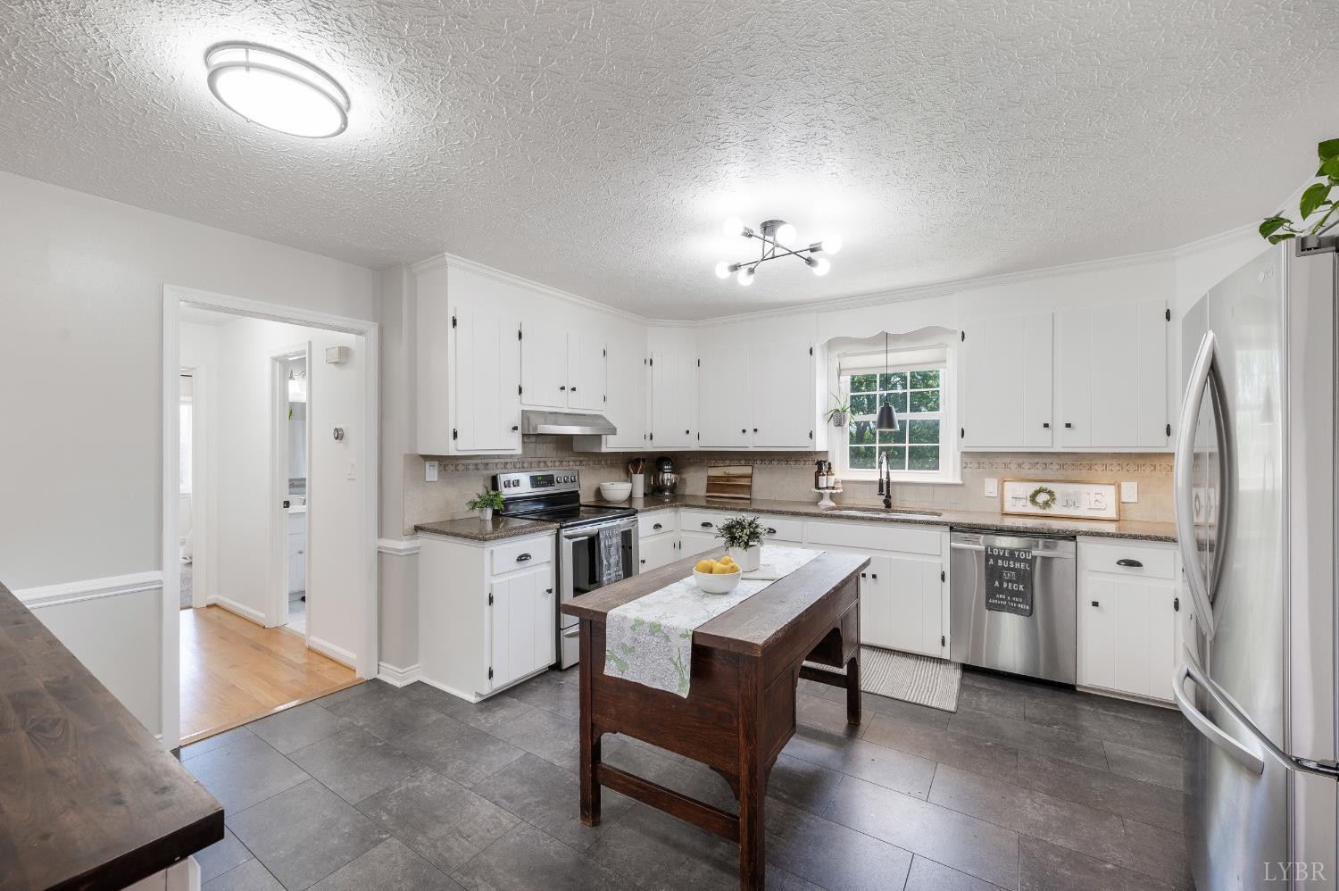 1199 Great Oak Road Forest, VA 24551 - Photo 21 of 85 a kitchen with a sink a stove a refrigerator and white cabinets