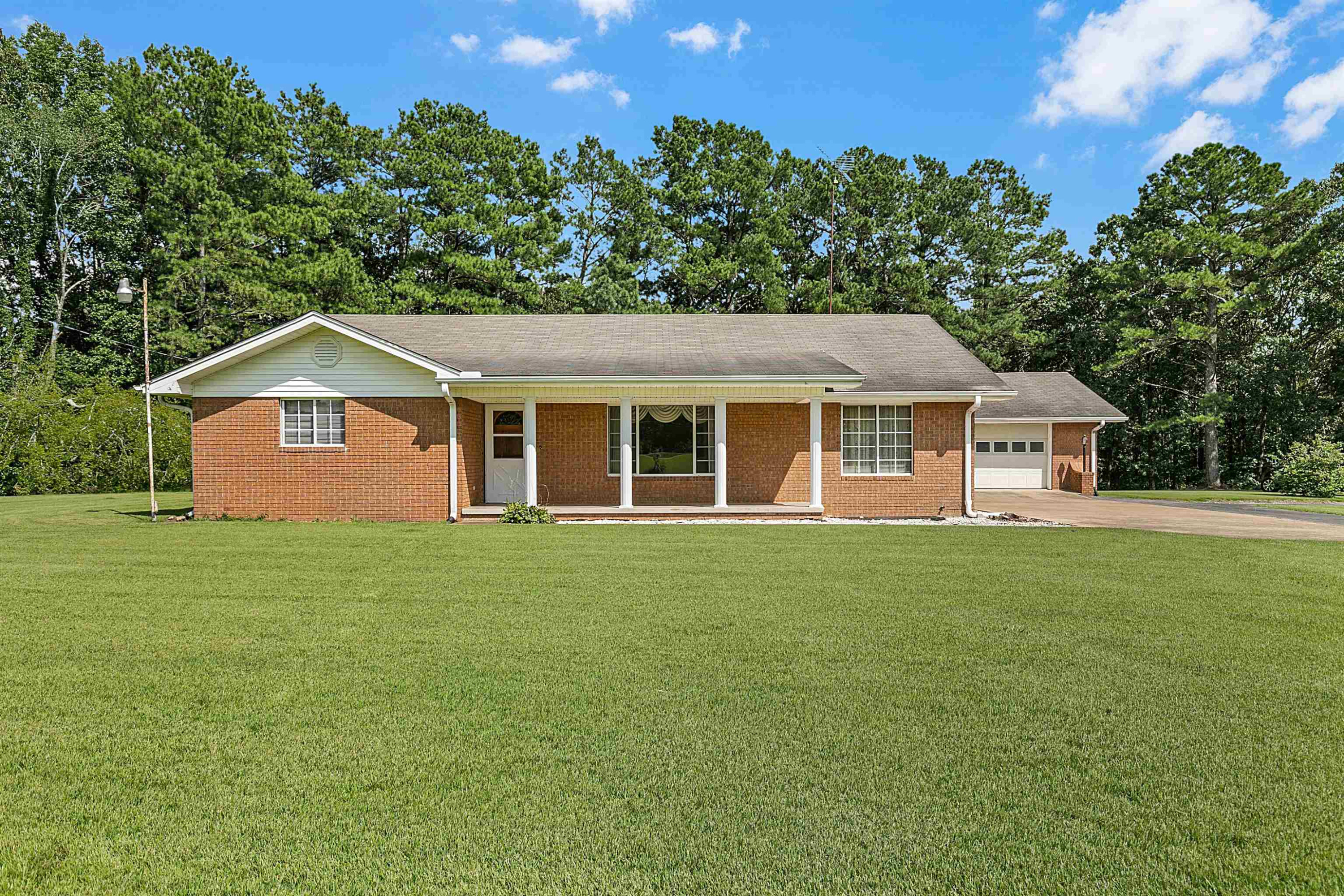 780 Griggs Chapel Road Cedar Grove, TN 38321 - Photo 2 of 25 a view of a yard in front of a house with a garden