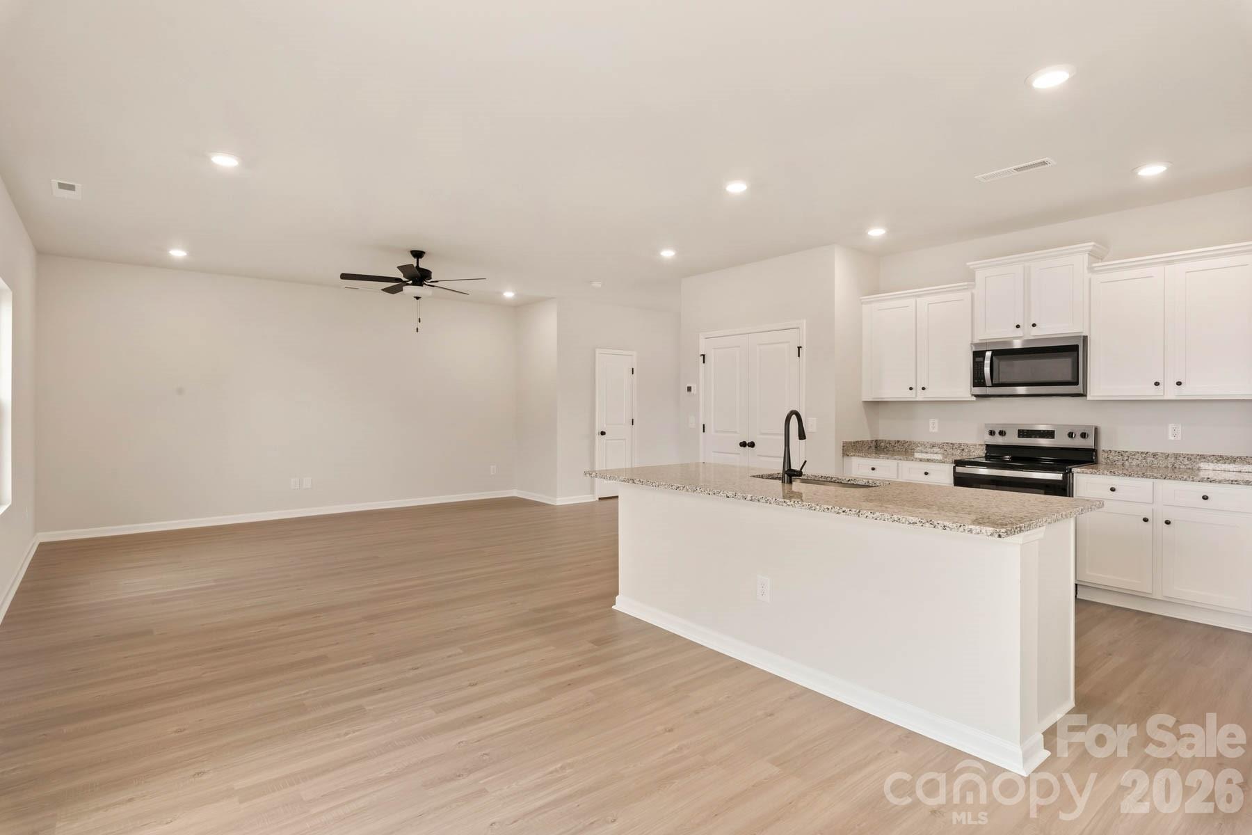 280 Limestone Terrace Salisbury, NC 28146 - Photo 11 of 21 a large white kitchen with kitchen island a sink a stove a microwave and white cabinets