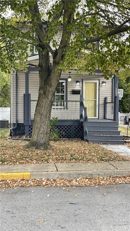 a front view of a house with a yard tree and wooden fence