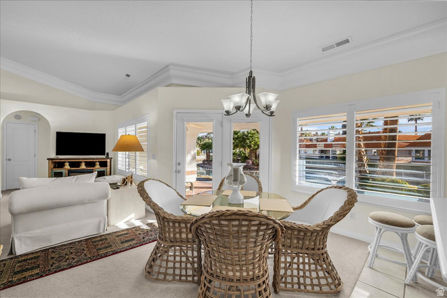 150 South Crystal Street, Unit 31 St. George, UT 84770 - Photo 10 of 20 Dining space featuring light colored carpet, hanging lights, arched walkways, and lofted ceiling