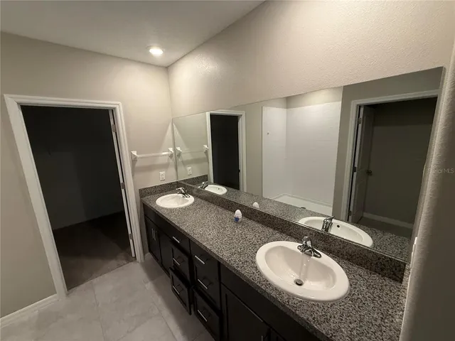a bathroom with a granite countertop sink and a mirror