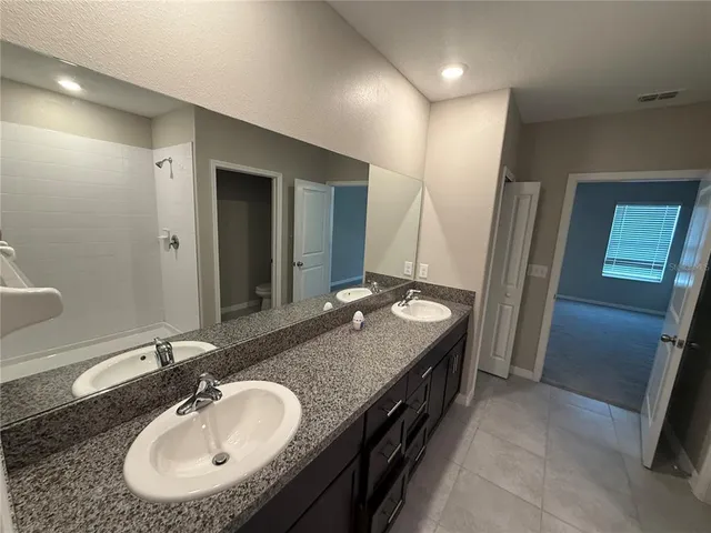 a bathroom with a double vanity sink and a mirror