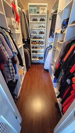 a view of walk in closet with clothes and shoes