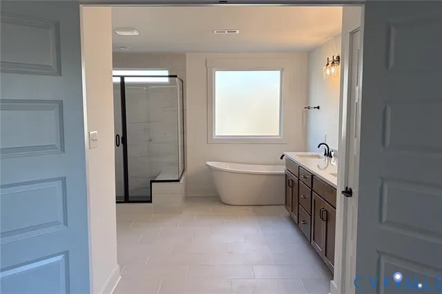 a bathroom with a tub a sink and a large mirror
