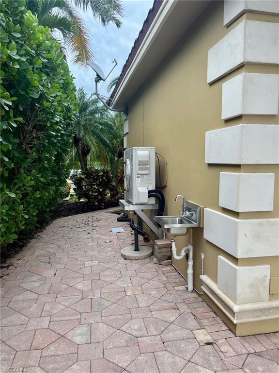 4931 Coach Lane Naples, FL 34114 - Photo 11 of 13 a view of a patio with table and chairs with plants and trees
