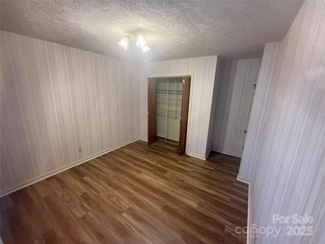 a view of a room with wooden floor and white walls