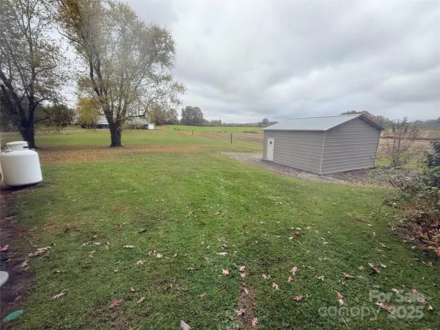 a view of a field with large trees