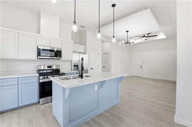 a kitchen with stainless steel appliances granite countertop a sink a stove and a refrigerator