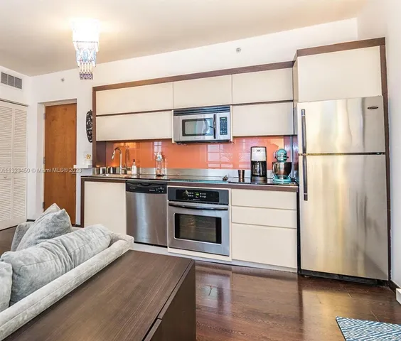a kitchen with stainless steel appliances a refrigerator and a stove top oven