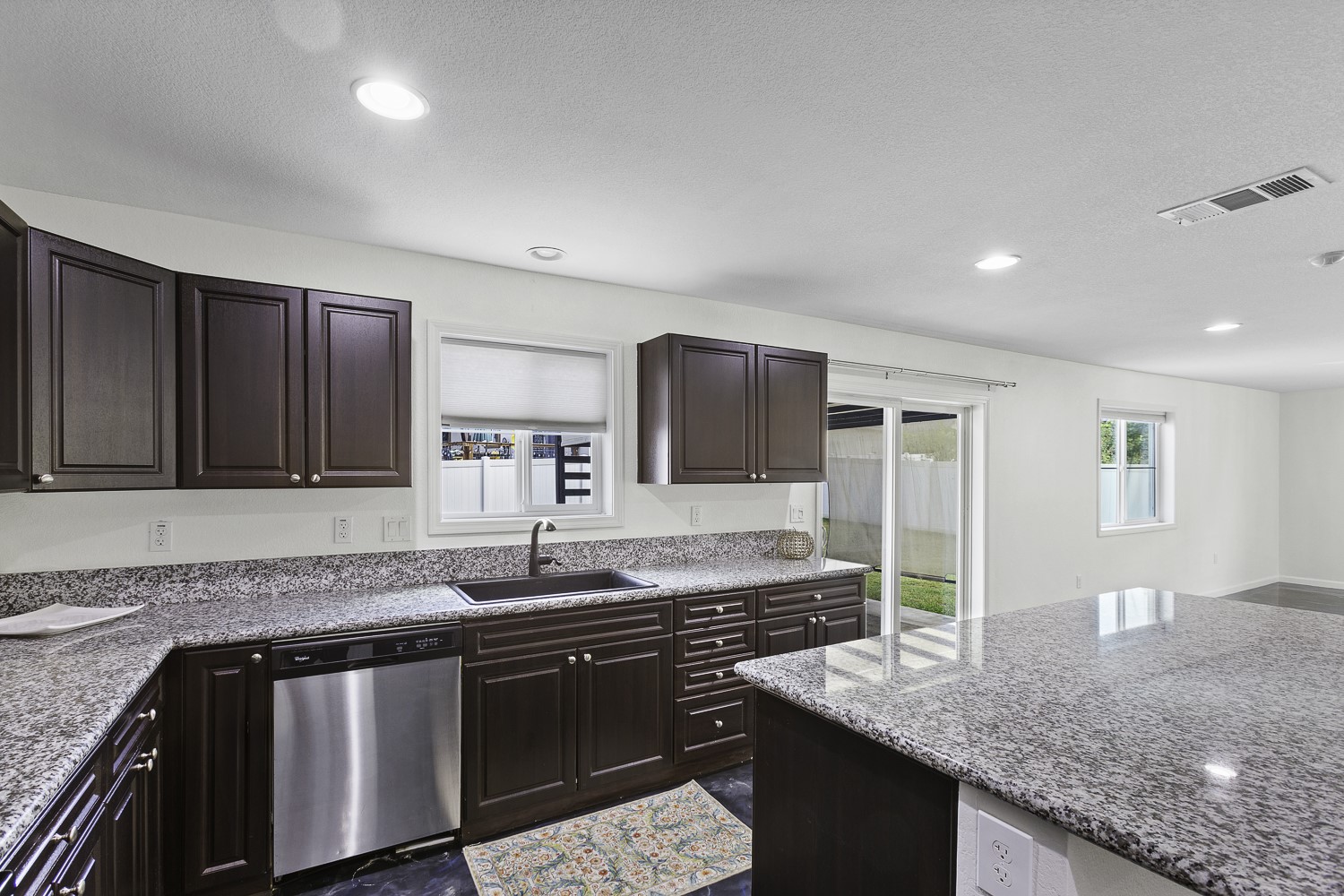 Undisclosed Address Austin, TX 78747 - Photo 4 of 28 a kitchen with granite countertop a sink and a wooden cabinets