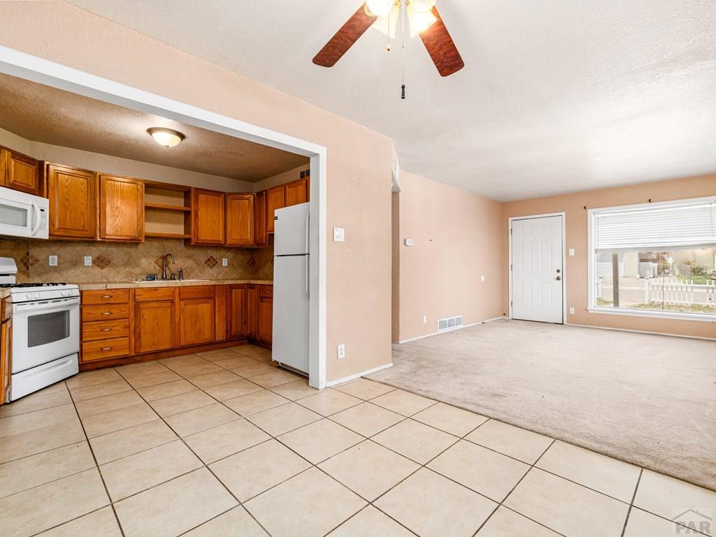2610 Azalea Street Pueblo, CO 81005 - Photo 5 of 19 a kitchen with stainless steel appliances kitchen island granite countertop a sink and cabinets