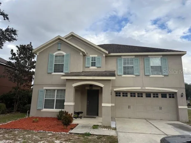 a view of a house with a yard and potted plants
