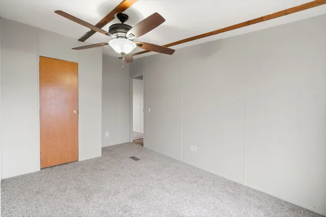 an empty room with a ceiling fan and a window