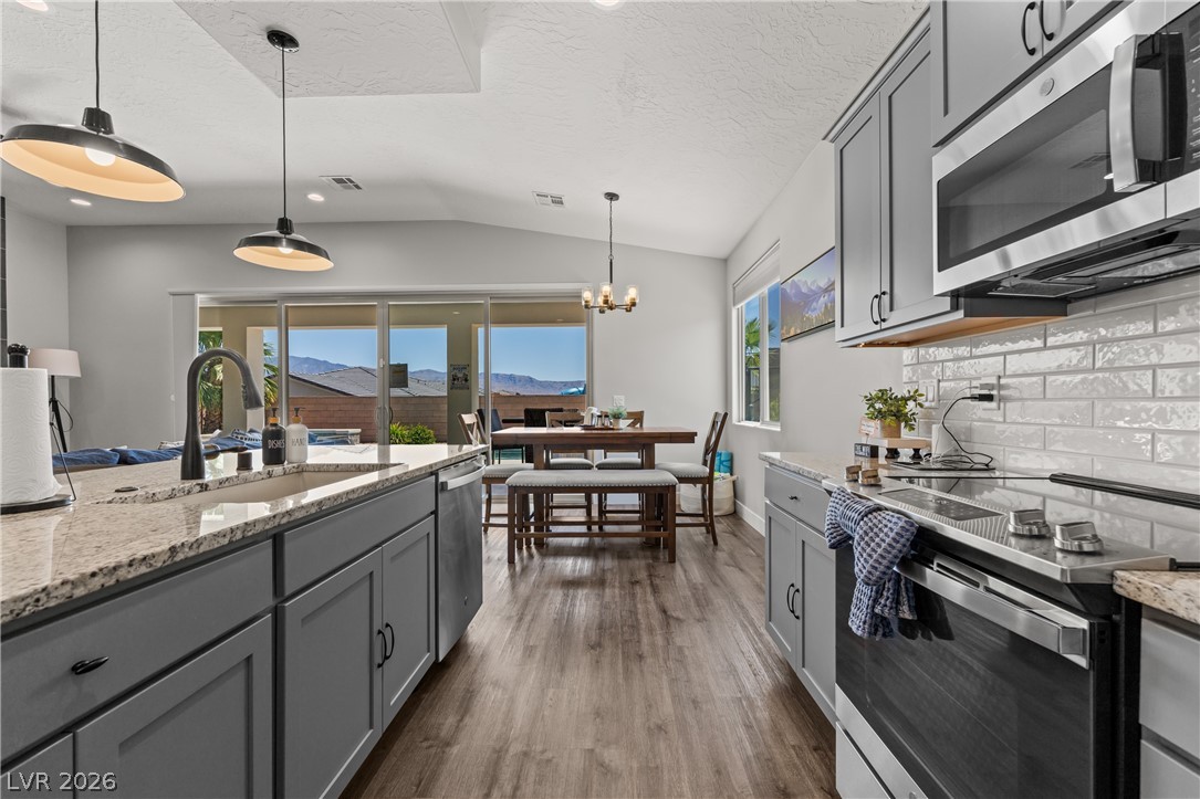 1436 Manassas Ridge Mesquite, NV 89027 - Photo 29 of 77 An open concept kitchen flows seamlessly into the dining area, featuring a modern range, stainless steel appliances, and a beautiful mountain view.