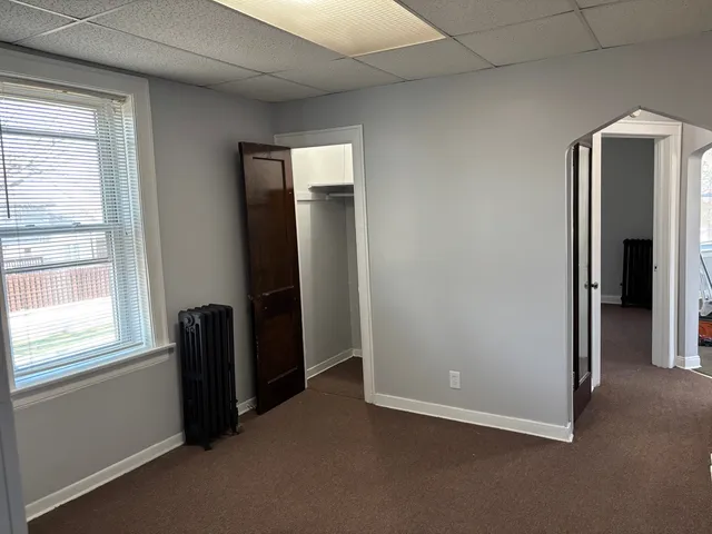 an empty room with windows and closet