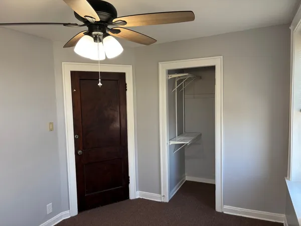 an empty room and chandelier fan