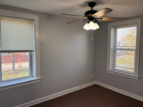 a room with a window and a chandelier fan