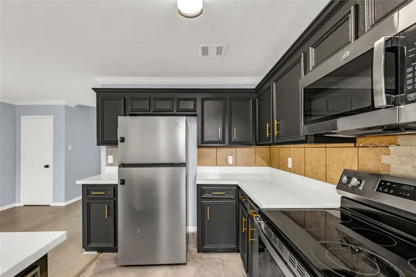 a kitchen with stainless steel appliances and a refrigerator