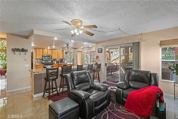 a living room with furniture kitchen view and a large window