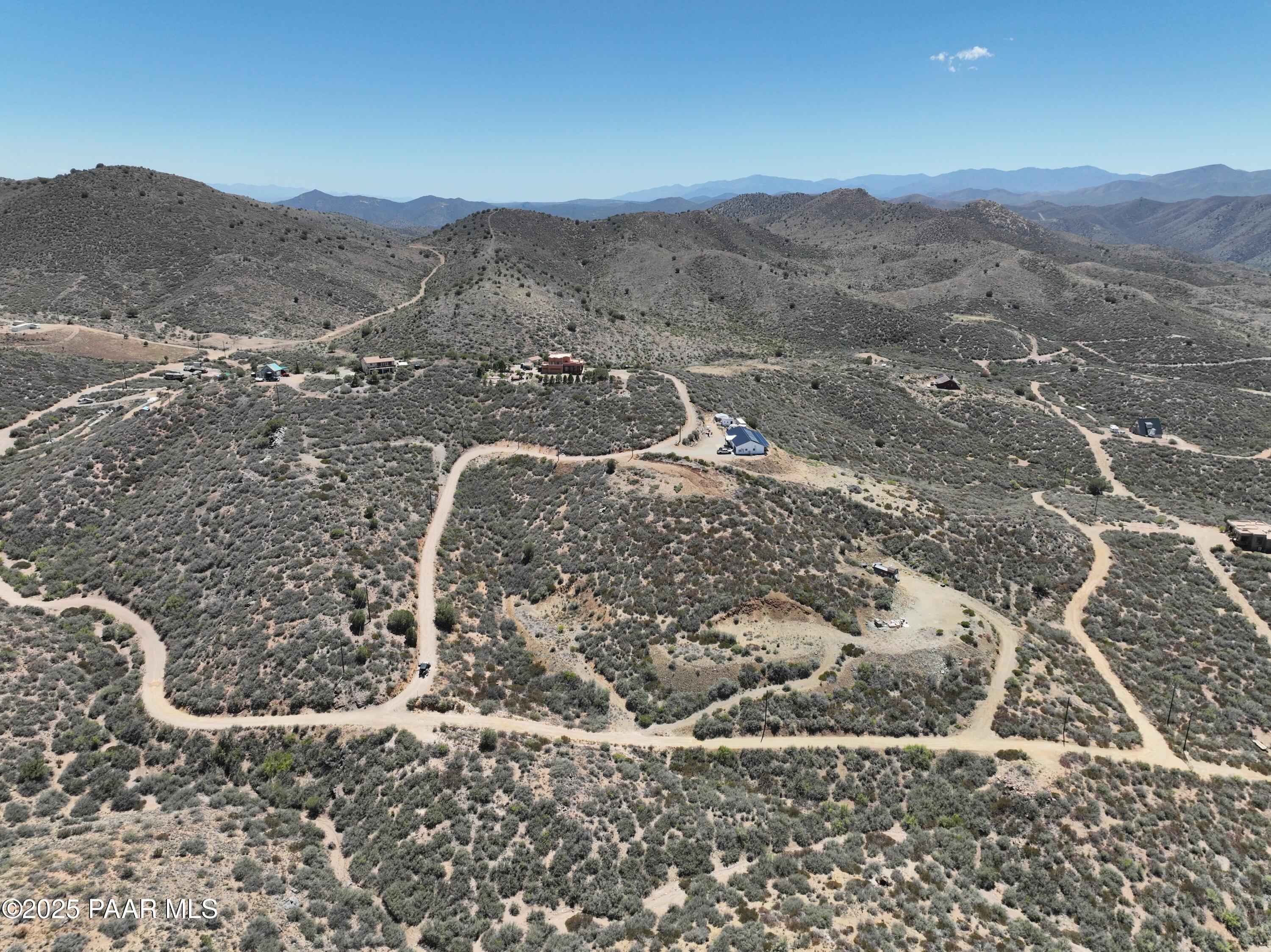 a view of a dry yard with mountains in the background