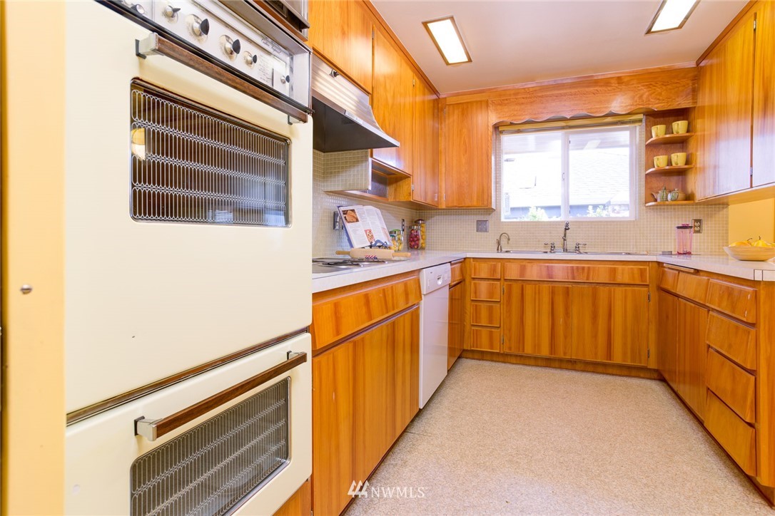 2347 North 64th Street Seattle, WA 98103 - Photo 4 of 25 a kitchen with a sink stove and cabinets