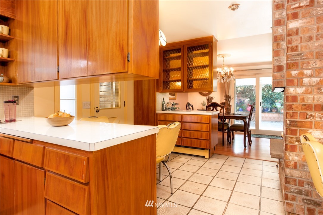 2347 North 64th Street Seattle, WA 98103 - Photo 5 of 25 a dining hall with stainless steel appliances kitchen island granite countertop a dining table and chairs
