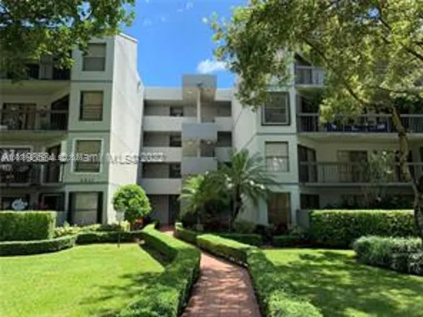 a front view of a multi story building with yard