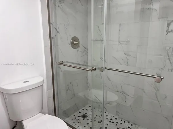 a white toilet sitting next to a bathroom