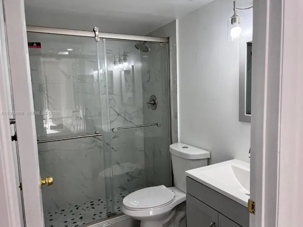 a bathroom with a shower a toilet and a sink