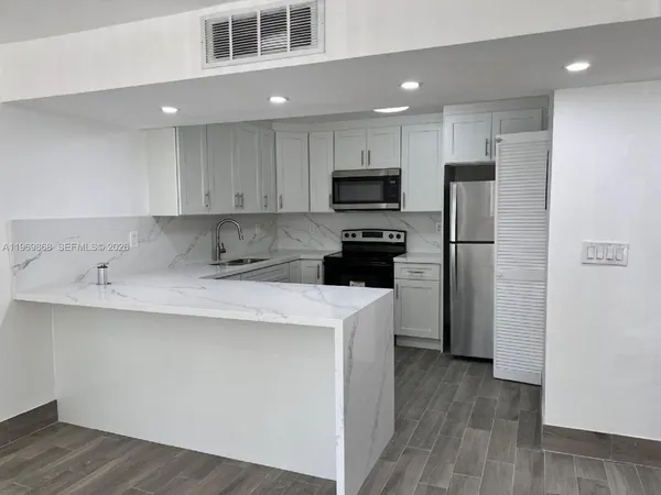 a kitchen with stainless steel appliances a refrigerator sink and microwave
