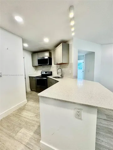 a kitchen with stainless steel appliances a refrigerator sink microwave and cabinets