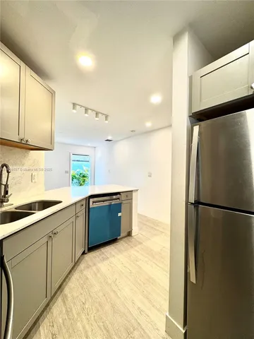 a kitchen with a refrigerator sink and cabinets