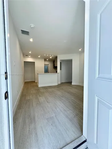 a view of a big room with wooden floor and a large window