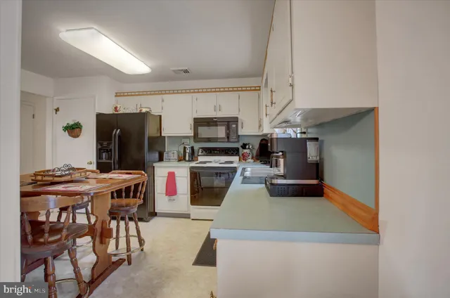 a kitchen with stainless steel appliances granite countertop a sink a stove a refrigerator and cabinets