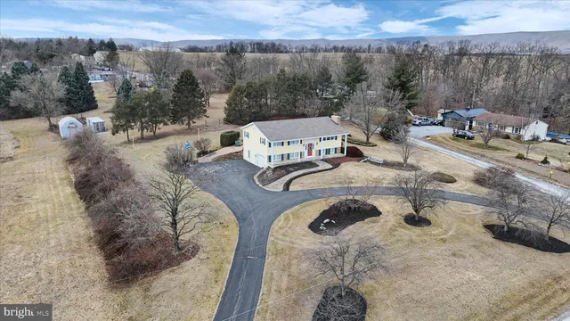 an aerial view of a house with a yard and sitting area