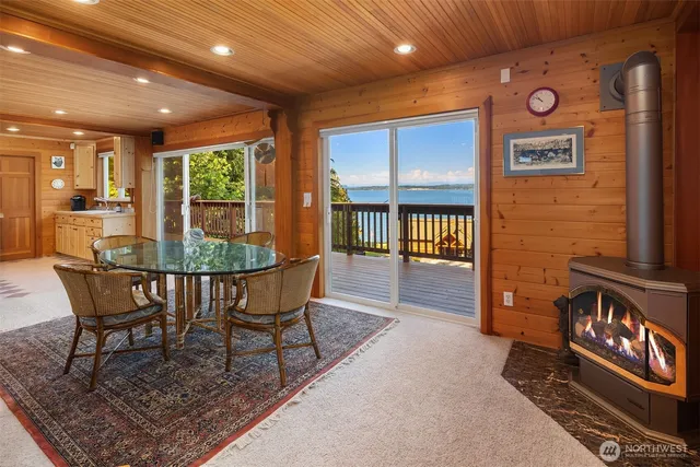 a dining room with furniture a rug and a floor to ceiling window